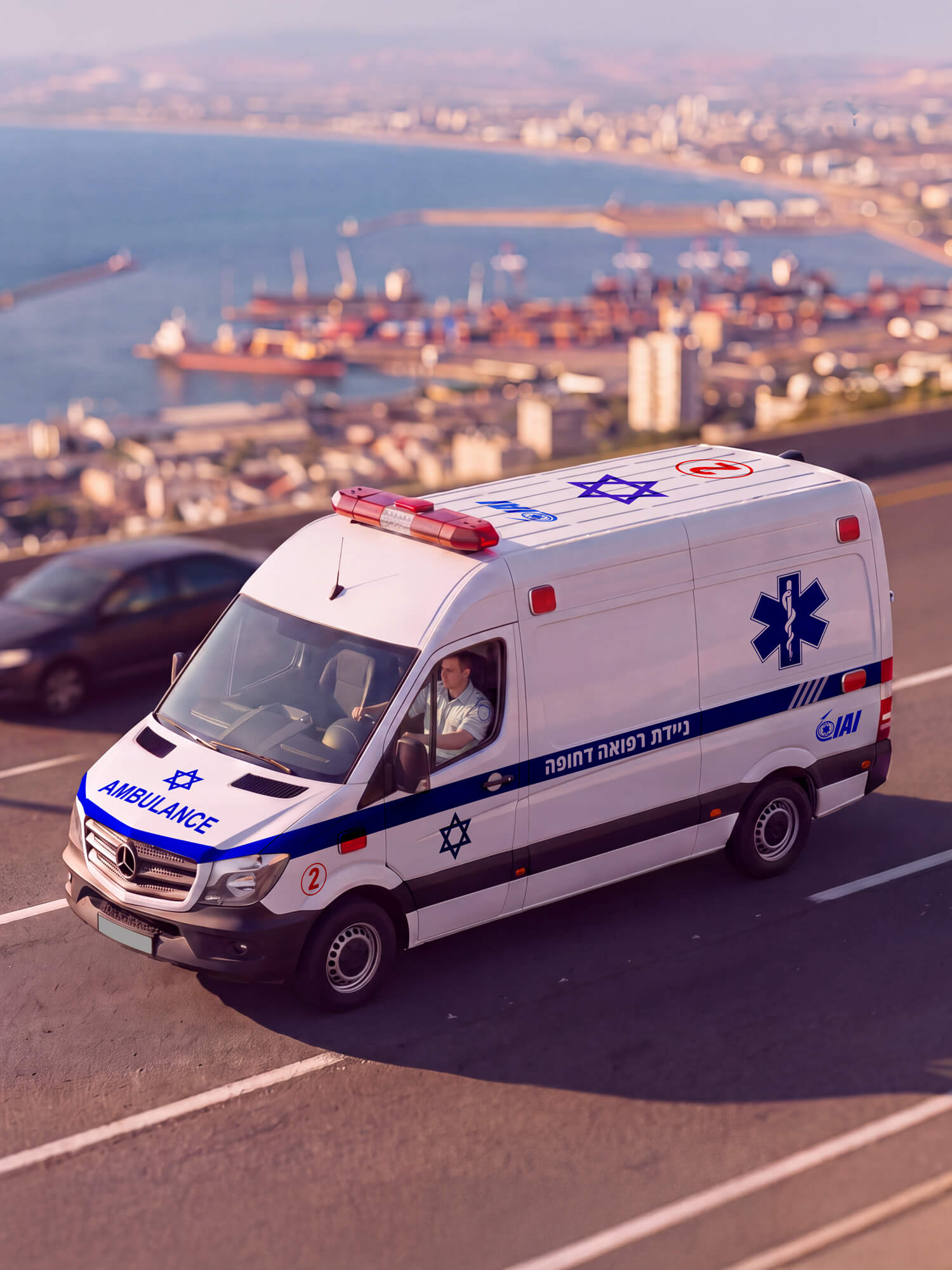 אמבולנס התעשייה האווירית לאחר דיגום, זיווד ומיתוג במפעל שפר־בר, על רקע נוף חיפה.